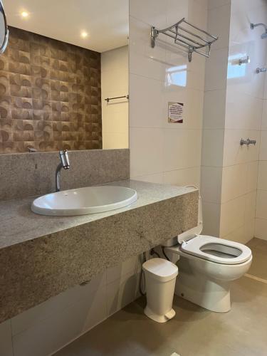 uma casa de banho com um lavatório e um WC em Bravo's Hotel em Xinguara