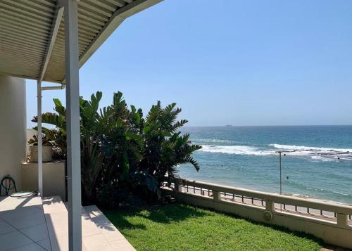 a view of the ocean from a balcony of a house at GARDEN ON THE BEACH in Umdloti