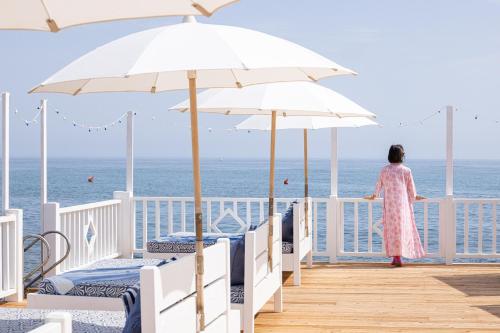 a woman standing on a deck looking out at the ocean at Masseria Torre Coccaro in Savelletri di Fasano