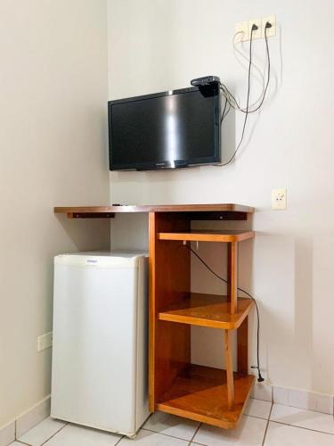 a television sitting on top of a table next to a refrigerator at Hotel Central de Anápolis in Anápolis