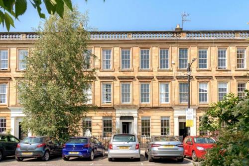 a large building with cars parked in front of it at Lovely 2 Bedroom Garden Flat in trendy West End in Glasgow