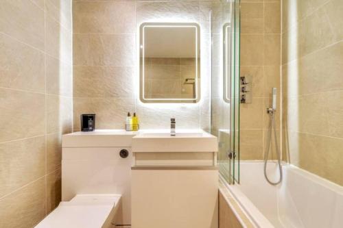 a bathroom with a sink and a shower and a mirror at Lovely 2 Bedroom Garden Flat in trendy West End in Glasgow