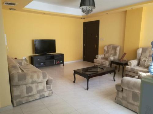 - un salon avec deux canapés et une télévision dans l'établissement Dream Home, à Amman