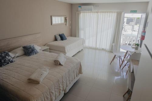 1 dormitorio con 2 camas, sofá y mesa en Saint Uriel en Puerto Madryn