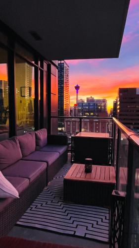 a balcony with a couch and a view of a city at LUXURY DT, 2 Bedroom DEAL, Private Balcony, Full Kitchen, Gym - FREE PARKING in Calgary