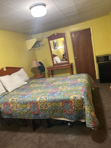 a hotel room with a bed with a colorful blanket at Budget Inn Motel Chemult in Chemult