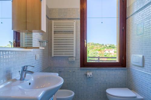 a bathroom with a sink and a toilet and a window at APPARTAMENTO BEL TRAMONTO Padulella Portoferraio in Portoferraio