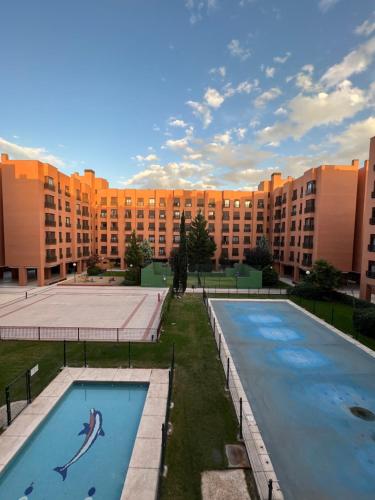 a large building with two swimming pools in front of it at Samaniego suite, AirPort, ifema turístico in Madrid