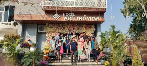 a group of people standing on the steps of a hotel at Hotel West End View in Zirakpur