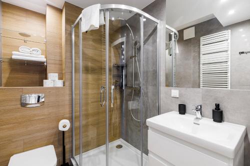 La salle de bains est pourvue d'une douche, d'un lavabo et de toilettes. dans l'établissement Balticus Apartamenty Standard Promenada Gwiazd 14, à Międzyzdroje