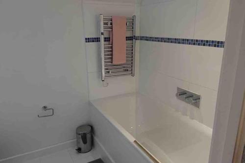 Baño blanco con bañera y espejo en A beautiful and cozy home in the heart of london, en Londres