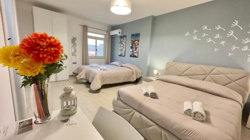 una sala de estar con 2 camas y un jarrón de flores en Colle Greco, en Agrigento