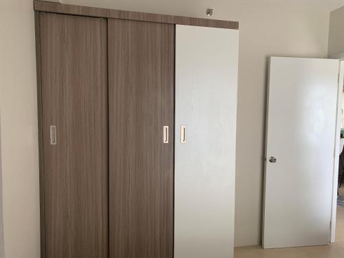 a room with two wooden cabinets and a mirror at RDC Cozy Suite in Tagaytay