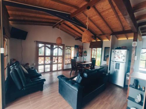 sala de estar con sofás, mesa y nevera en Espectacular Casa-Bonobo house al lado del rio en Acacías