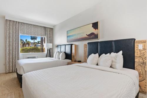 um quarto de hotel com duas camas e uma janela em Postcard Inn On The Beach em St. Pete Beach
