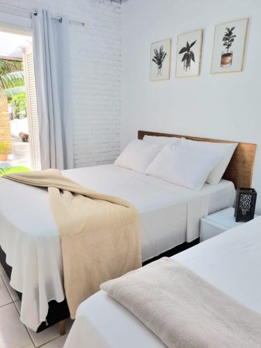 a bedroom with two beds and a window at Yabás Praia in Ubatuba