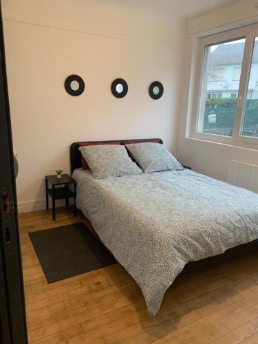 a bedroom with a bed with three clocks on the wall at Bel appartement neuf avec jardin, proche mer in Calais