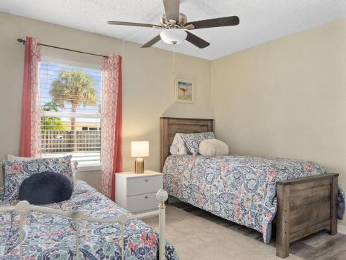 a bedroom with two beds and a ceiling fan at 2 Bedroom-1.5 Bath Apartment Steps away from Beach & Inlet d in Fort Pierce