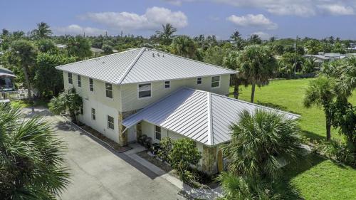 an aerial view of a white house with palm trees at 2 Bedroom-1.5 Bath Apartment Steps away from Beach & Inlet d in Fort Pierce