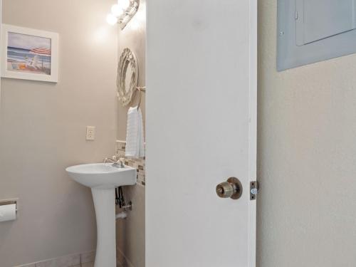 a white bathroom with a sink and a mirror at 2 Bedroom-1.5 Bath Apartment Steps away from Beach & Inlet d in Fort Pierce