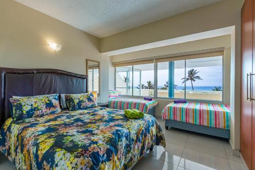 - une chambre avec un lit et une vue sur la plage dans l'établissement 17 Stella Maris Seaside @ Van's, à Amanzimtoti