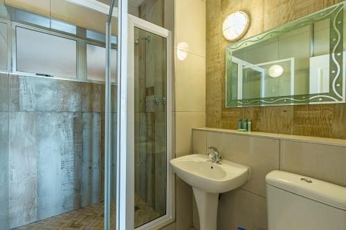 La salle de bains est pourvue d'une douche, d'un lavabo et d'un miroir. dans l'établissement 17 Stella Maris Seaside @ Van's, à Amanzimtoti