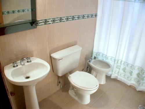 y baño con aseo, bidet y lavamanos. en Cabañas Costa Vergel en Los Reartes