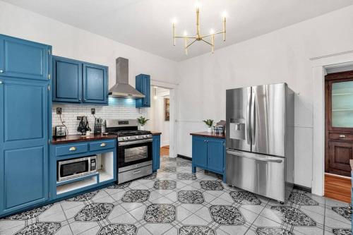 cocina con armarios azules y nevera de acero inoxidable en Exquisite two-story home located in Midtown en Memphis