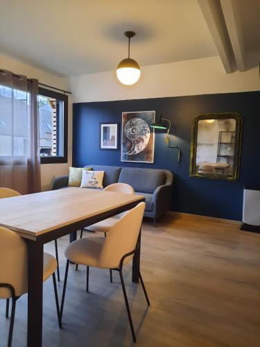 une salle à manger avec une table, des chaises et un canapé dans l'établissement Le Blue Moon - 50m centre historique - parking privatif, à Sarlat-la-Canéda