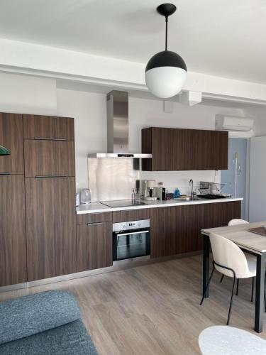 uma cozinha com armários de madeira e uma mesa de jantar em Le Blue Moon - 50m centre historique - parking privatif em Sarlat-la-Canéda