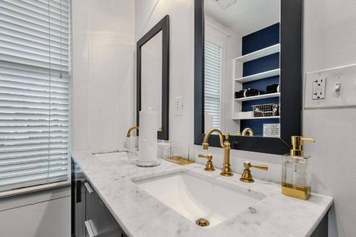 a white bathroom with a sink and a mirror at Exquisite two-story home located in Midtown in Memphis