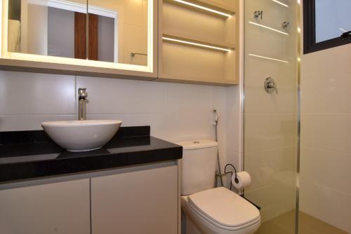 a bathroom with a sink and a toilet and a shower at Chez Soleil, Cobertura com Jacuzzi e Vista Mar P1408 in Florianópolis