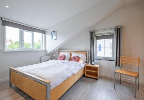 a bedroom with a bed with two people on it at Private, 5-star vacation home on a beautiful island in De Cocksdorp