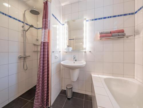 a white bathroom with a sink and a tub and a shower at Private, 5-star vacation home on a beautiful island in De Cocksdorp