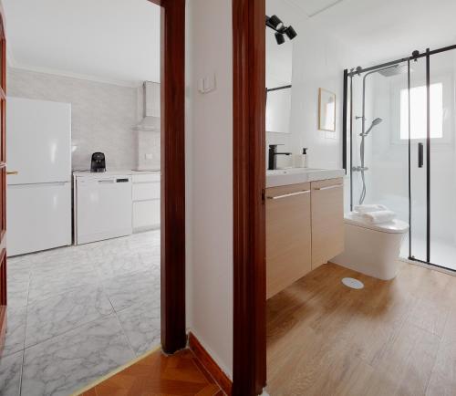 cocina blanca con ducha y aseo en 165A Apto moderno 2 dormitorios en Gijón