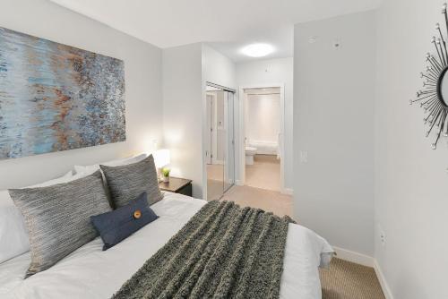 a bedroom with a bed with a painting on the wall at Duet Executive Stay in Victoria