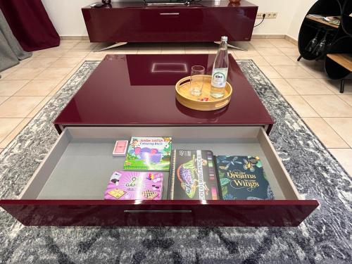 a coffee table with books and a bottle on it at A&D Charmantes Apartment - Bühlertal bei Bühl, Baden-Baden & Schwarzwald in Bühlertal