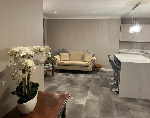 a living room with a couch and a table with flowers at Buckingham Court in St. Albans