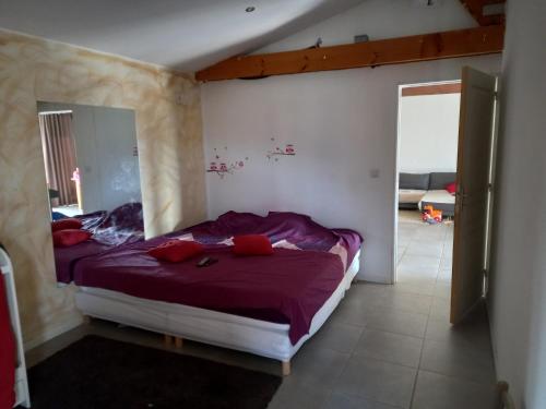 ein Schlafzimmer mit einem Bett mit lila Laken und einem Spiegel in der Unterkunft Ducourneau Grimaldi in Moltifao