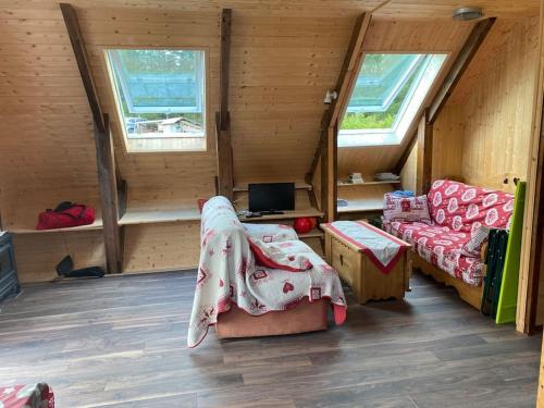 ein Zimmer mit einem Bett und einem Sofa in einer Hütte in der Unterkunft Chalet cosy, belle vue, dans le massif du Vercors in Lans-en-Vercors