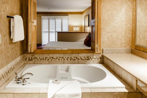 La salle de bains est pourvue d'une baignoire et d'un lit. dans l'établissement Tenaya at Yosemite, à Fish Camp
