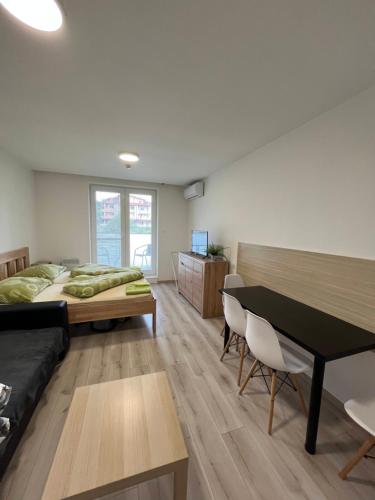 een slaapkamer met een bed, een bureau en een tafel bij Apartmán Paula 2 in Podhájska