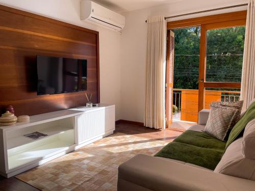 ein Wohnzimmer mit Sofa und Fernseher in der Unterkunft Apto 3 Quartos Centro Gramado in Gramado