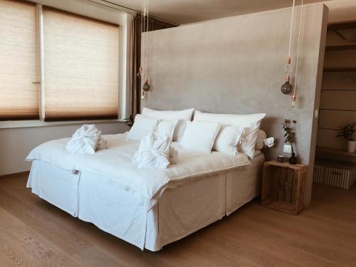 a bed with white sheets and pillows in a room at AVLiving City INSIDE NINE Basel in Basel