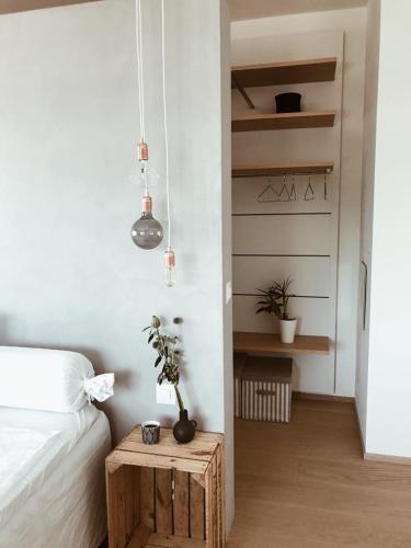 a bedroom with a bed and a table with a plant at AVLiving City INSIDE NINE Basel in Basel