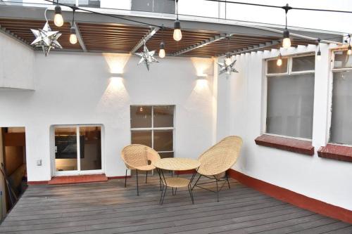 un patio con 2 sillas y una mesa en un edificio en Apartment & private terrace Sunlight residence, en Ciudad de México