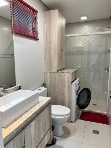 uma casa de banho com um lavatório, um WC e um chuveiro em Miramar em Balneário Camboriú