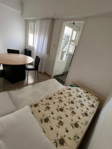 Habitación pequeña con cama y mesa en Departamento en el centro de Mar del plata en Mar del Plata