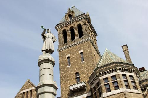 uma estátua no topo de um edifício com uma torre em City Hall Grand Hotel em Williamsport