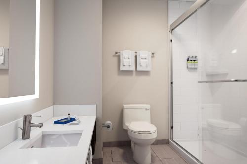 y baño blanco con aseo y ducha. en Holiday Inn Express & Suites - Phoenix West - Tolleson, an IHG Hotel, en Phoenix